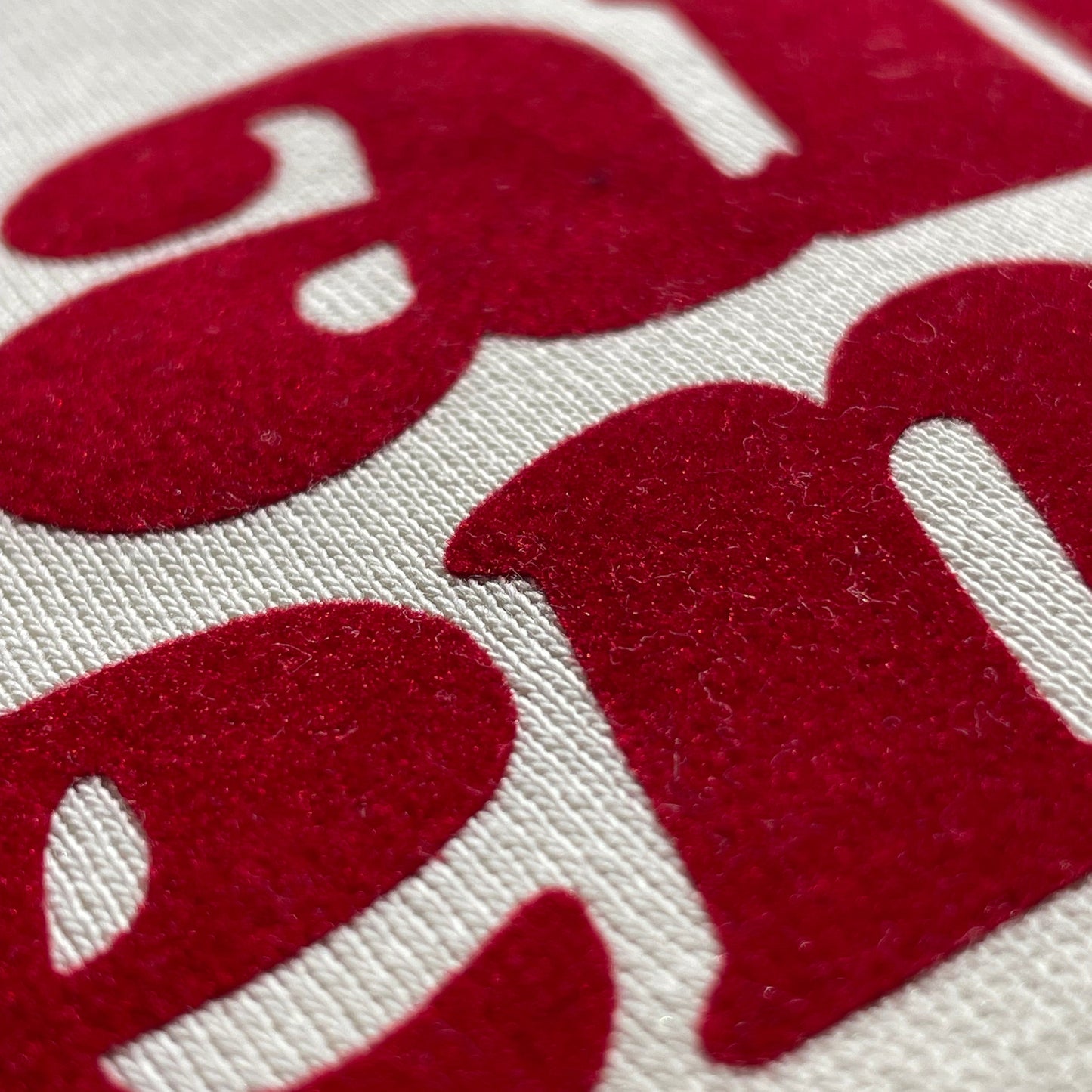 detalle sudadera color crema de algodón con mensaje en terciopelo rojo