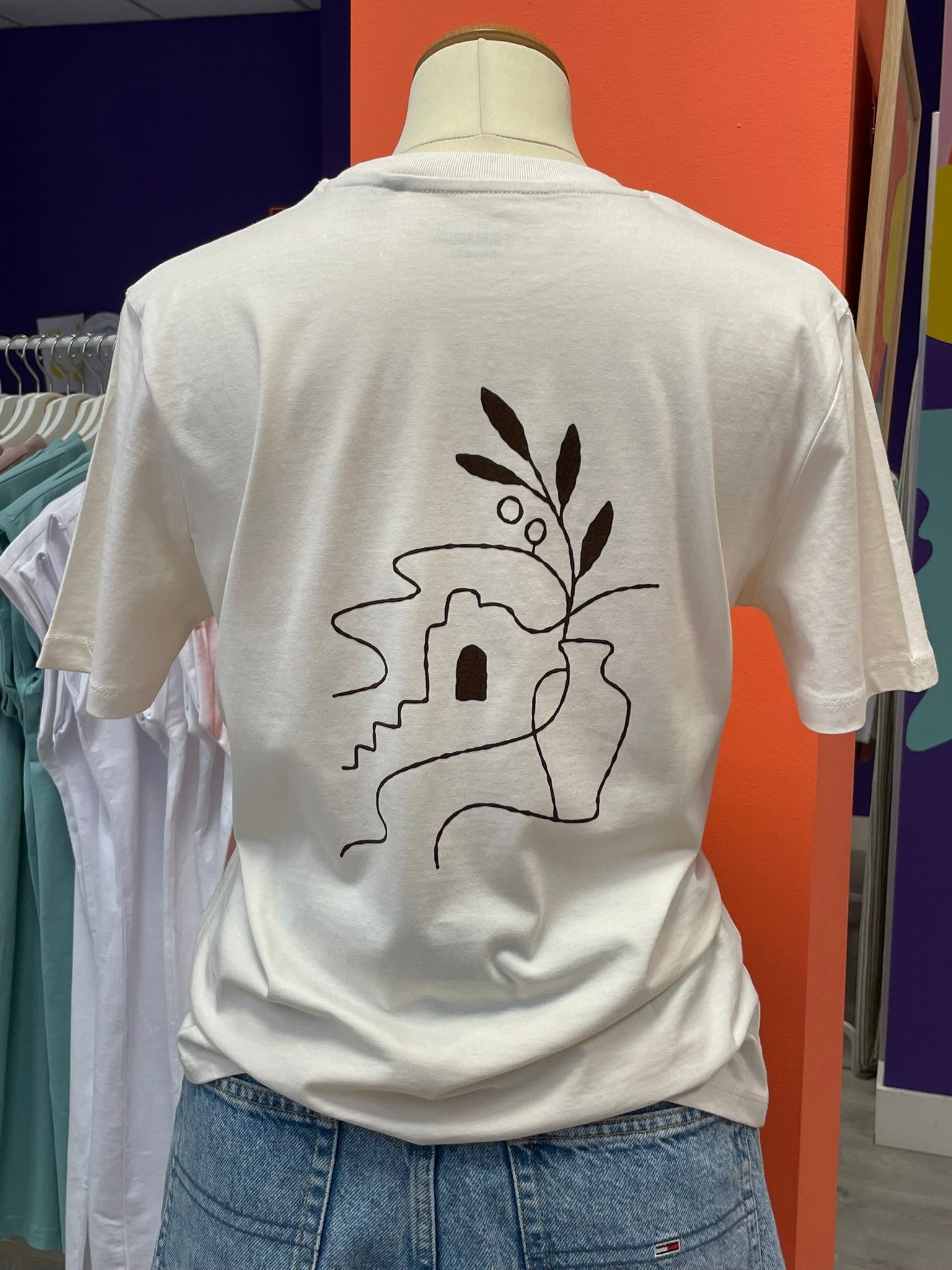 Camiseta unisex offwhite de algodón orgánico con un dibujo de un paisaje mediterráneo en marrón terciopelo
